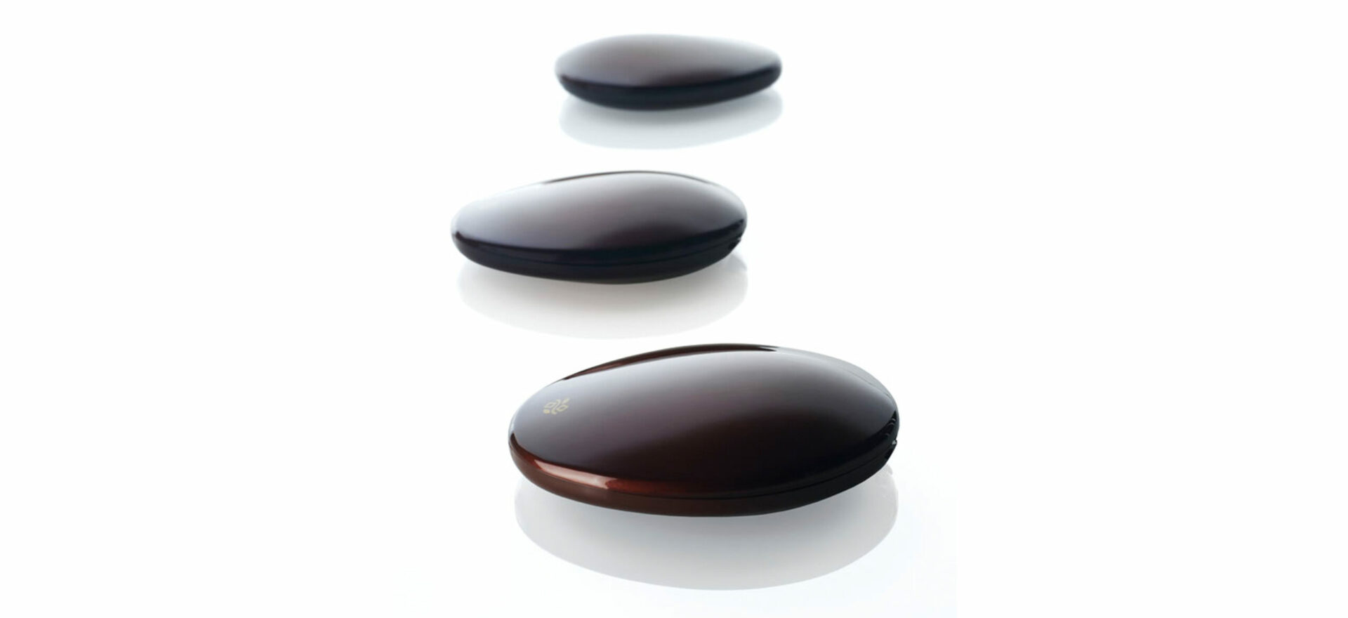 Three packaging of Deborah Milano make up designed with the form of river stones in plastic with a withe background.