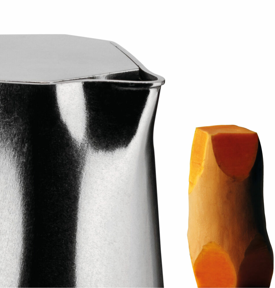 Close up detail of the Ossidiana Coffee Maker spout with a carved pumpkin inspired in the antiche forms of the arrowheads handmade by the natives in stone, with a white background.